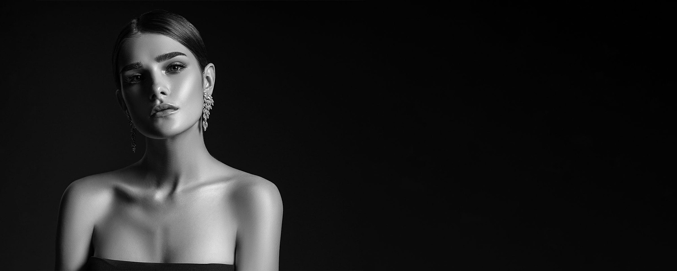 woman with slicked back hair and large earrings