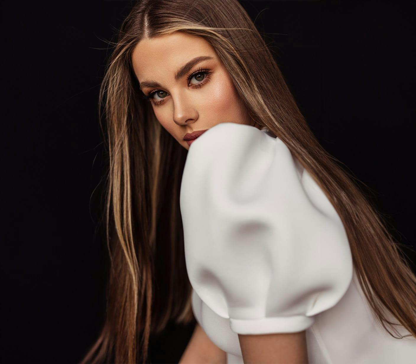 womans face partially hidden behind her puff sleeve dress