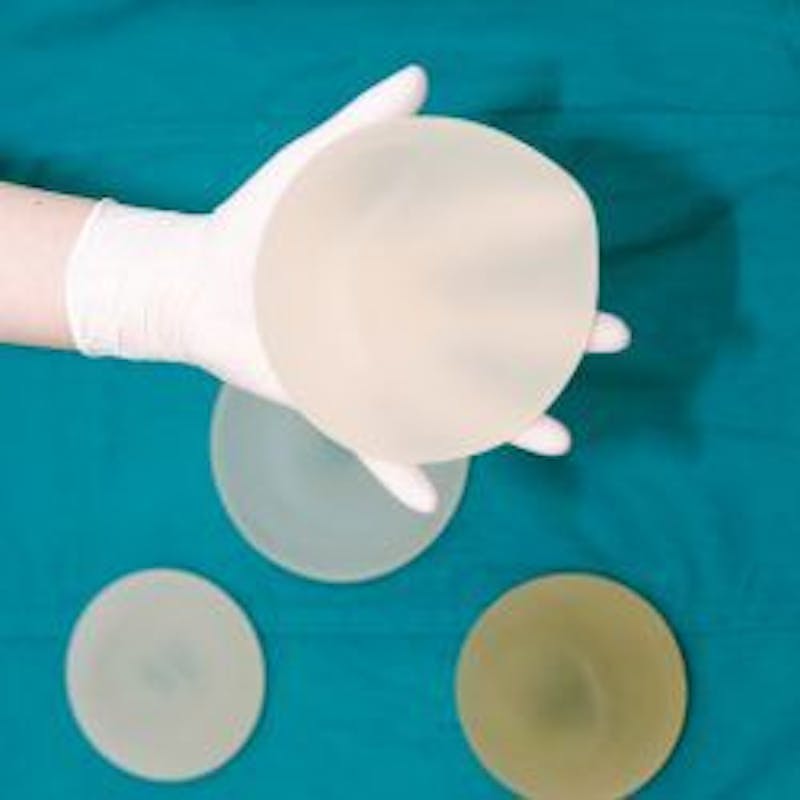 Hand holding breast implant