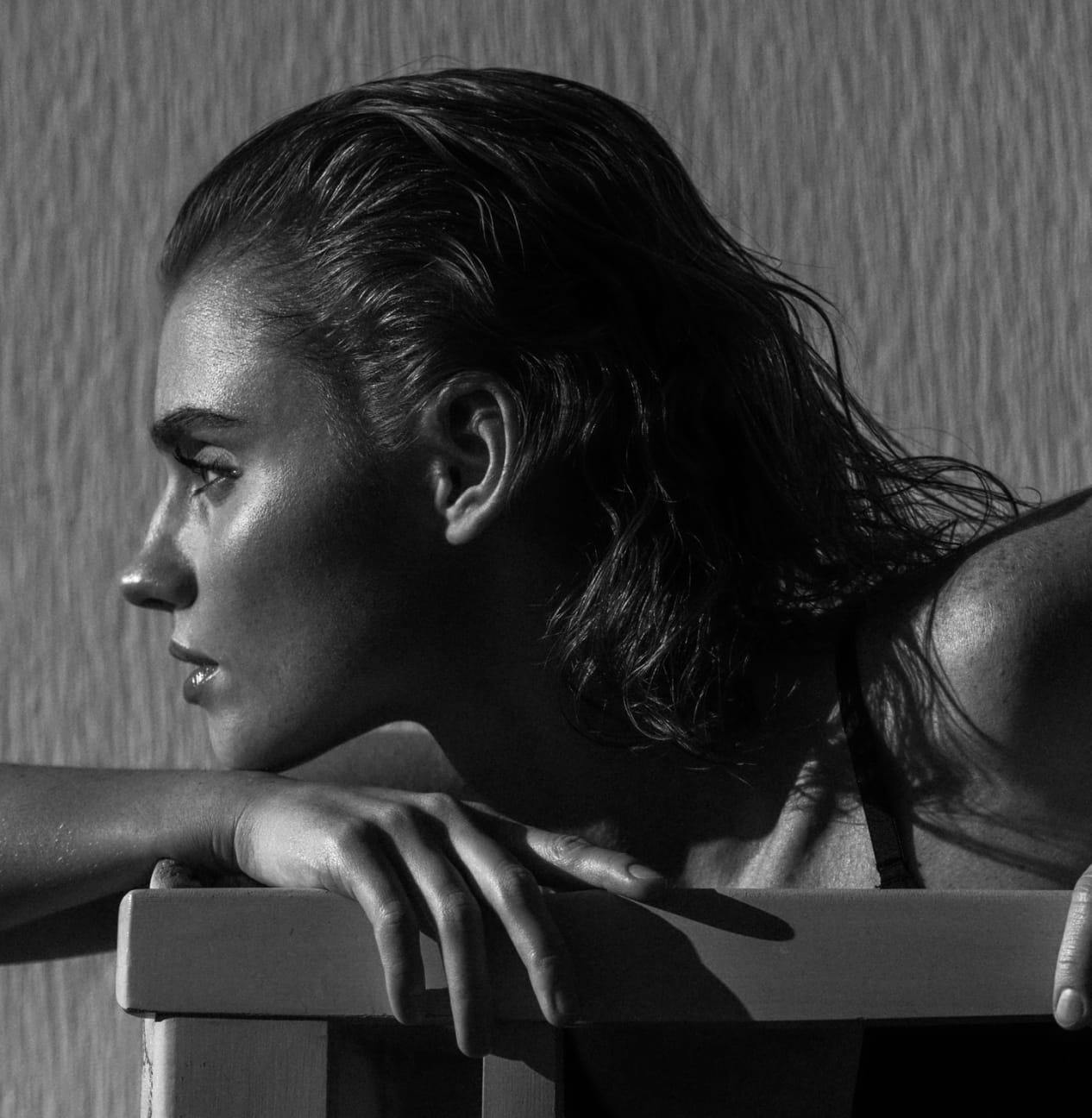 Woman leaning on a ledge, looking off to the left