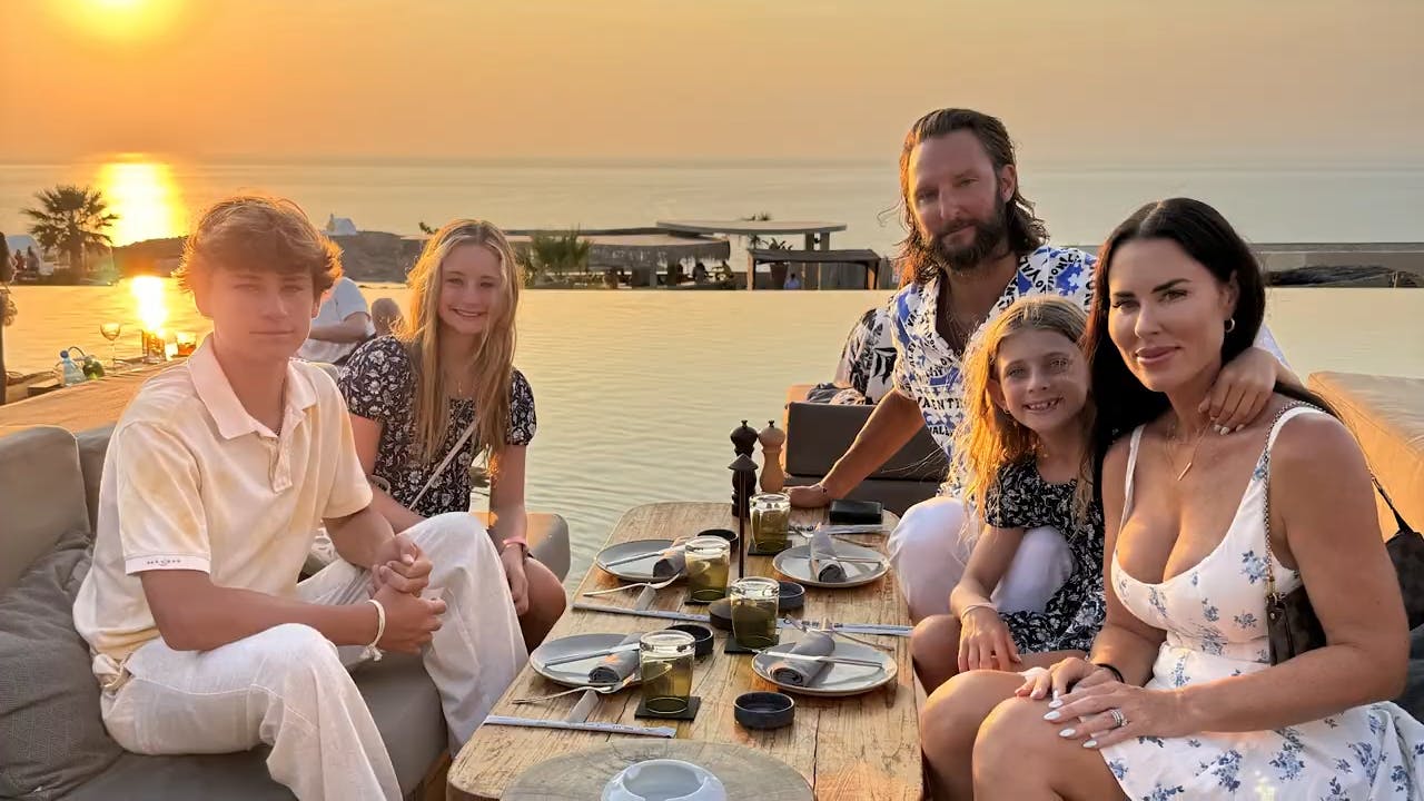 a family at a table in front of the ocean