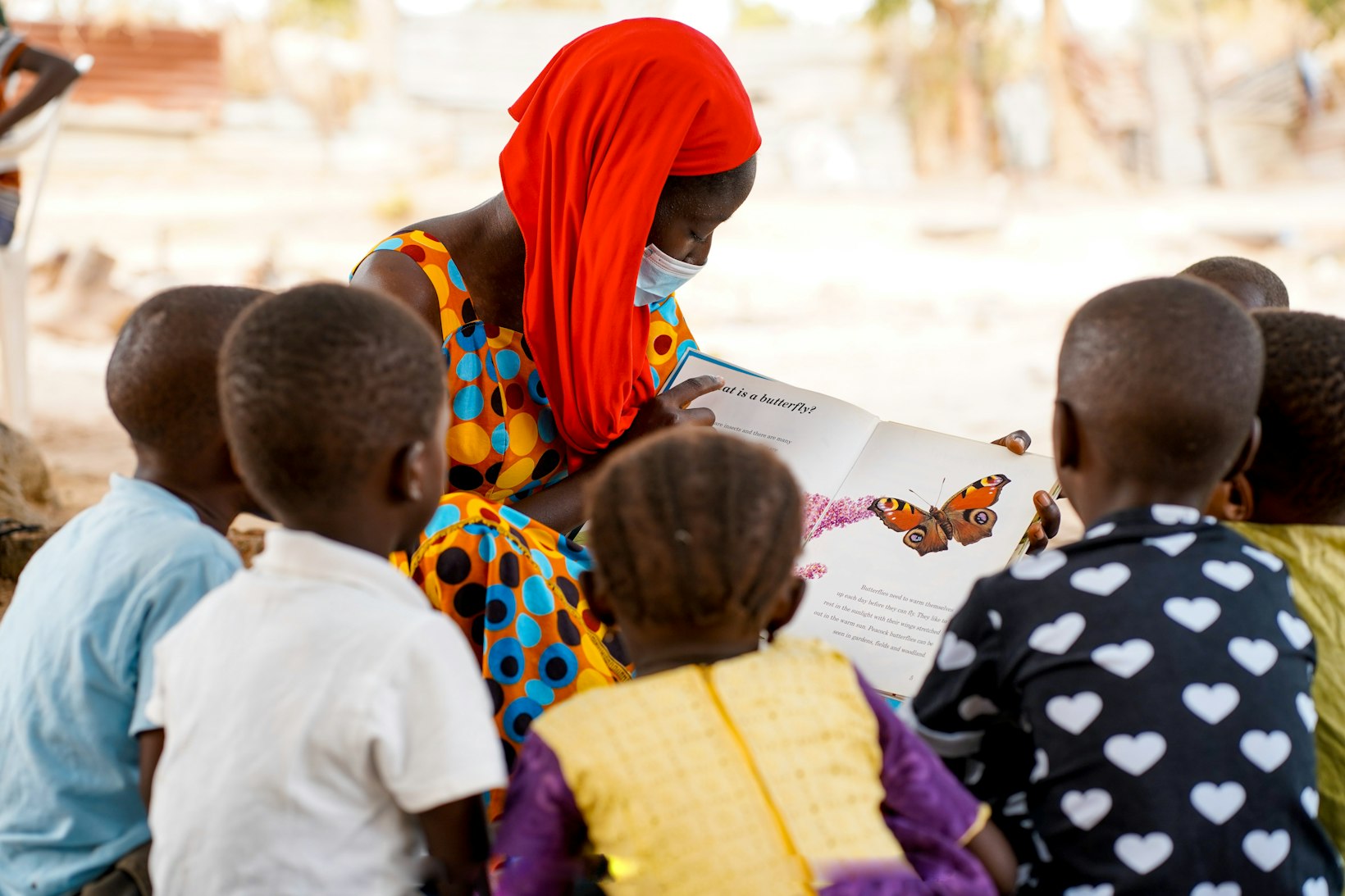 Teacher reading to students, The Gambia