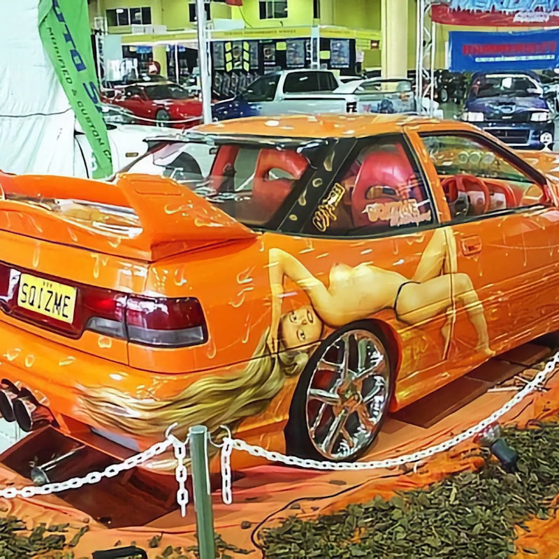 Orange S Coupe with pin-up girl airbrushing and SQIZME plate at car show