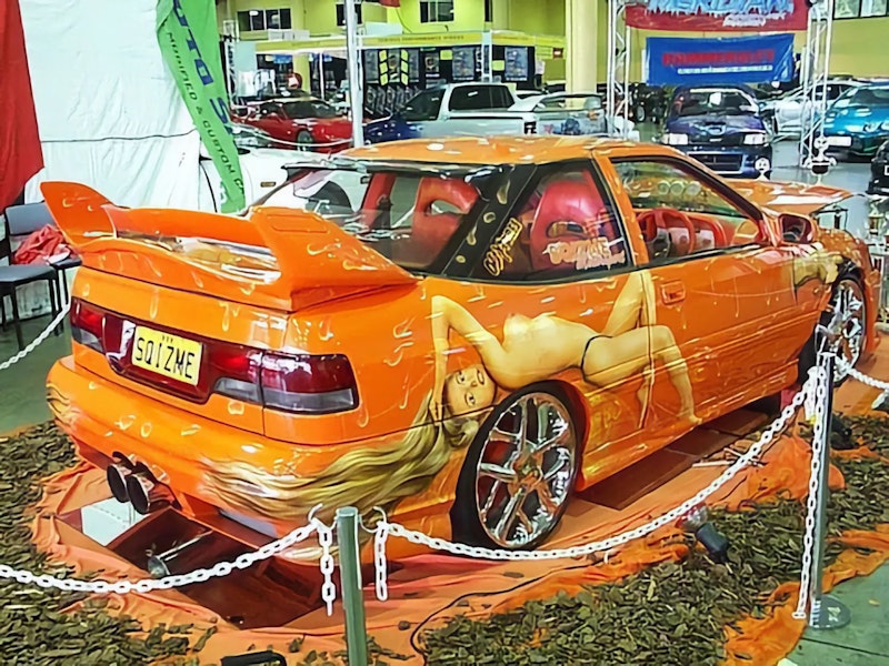 Orange S Coupe with pin-up girl airbrushing and SQIZME plate at car show