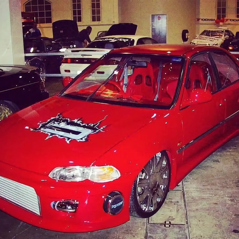 Red Honda Civic with airbrushed hood art and chrome wheels