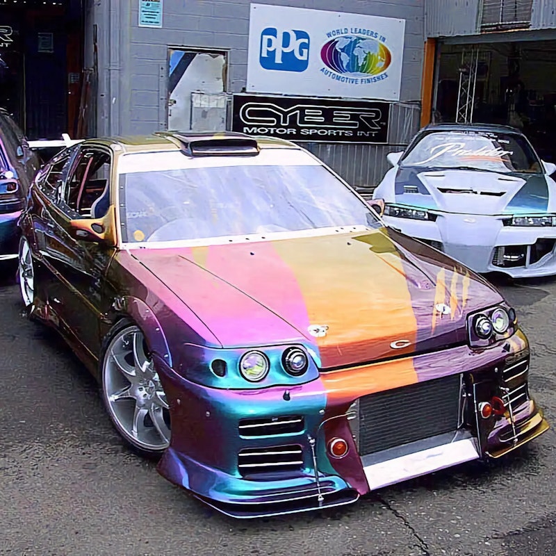 Front view of the completed CRX outdoors showing the two-tone gold-purple harlequin split, NSW "CYBER1" plate, intercooler bumper, Recaro seats visible inside, and rooftop scoop.