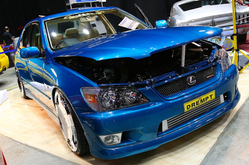 Blue Lexus IS200 with chrome rims and front-mount intercooler.