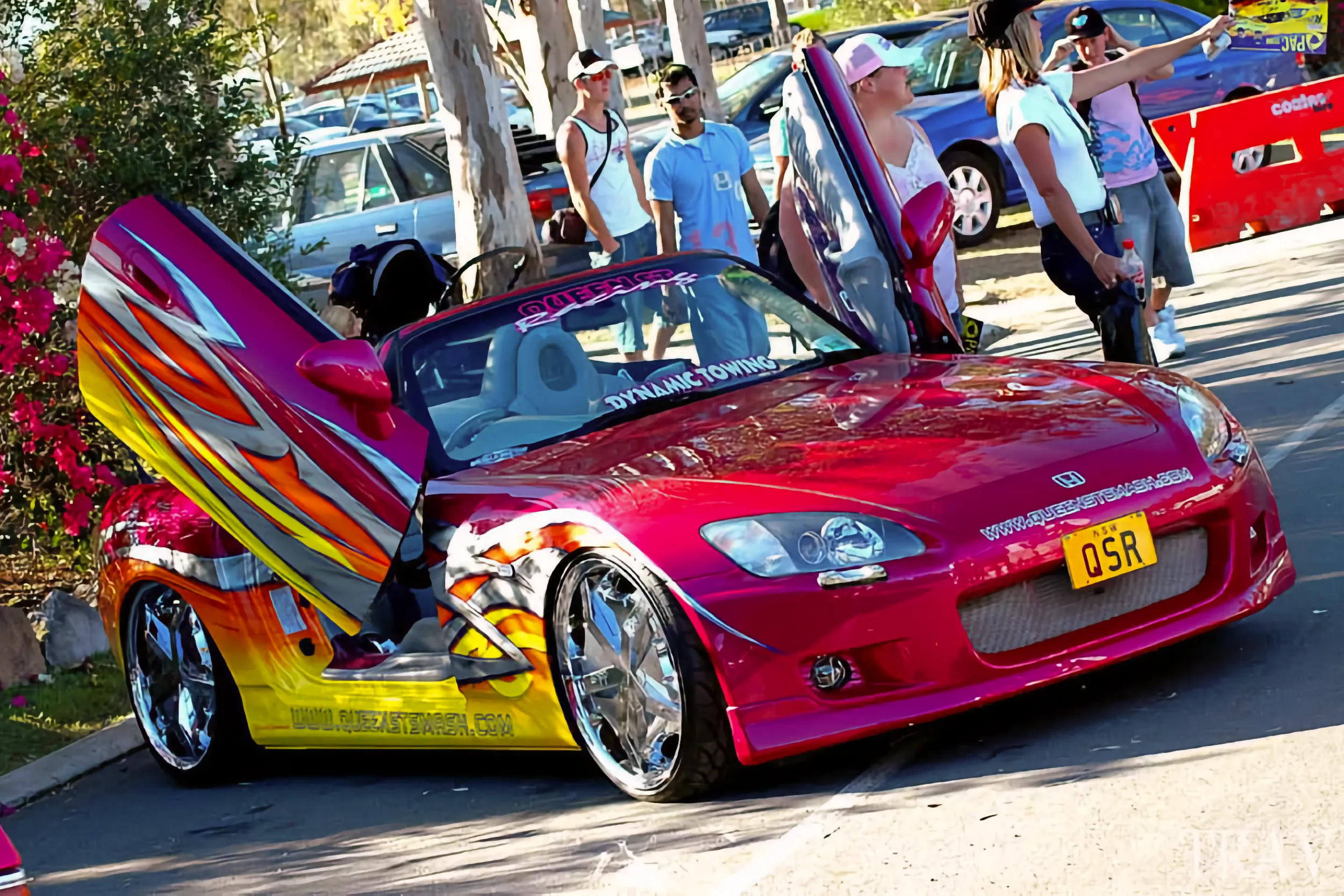 Pink Honda S2000 with chrome rims and scissor doors.