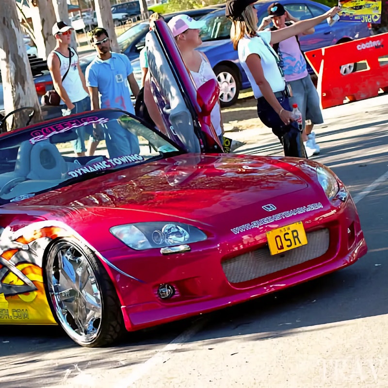 Pink Honda S2000 with chrome rims and scissor doors.
