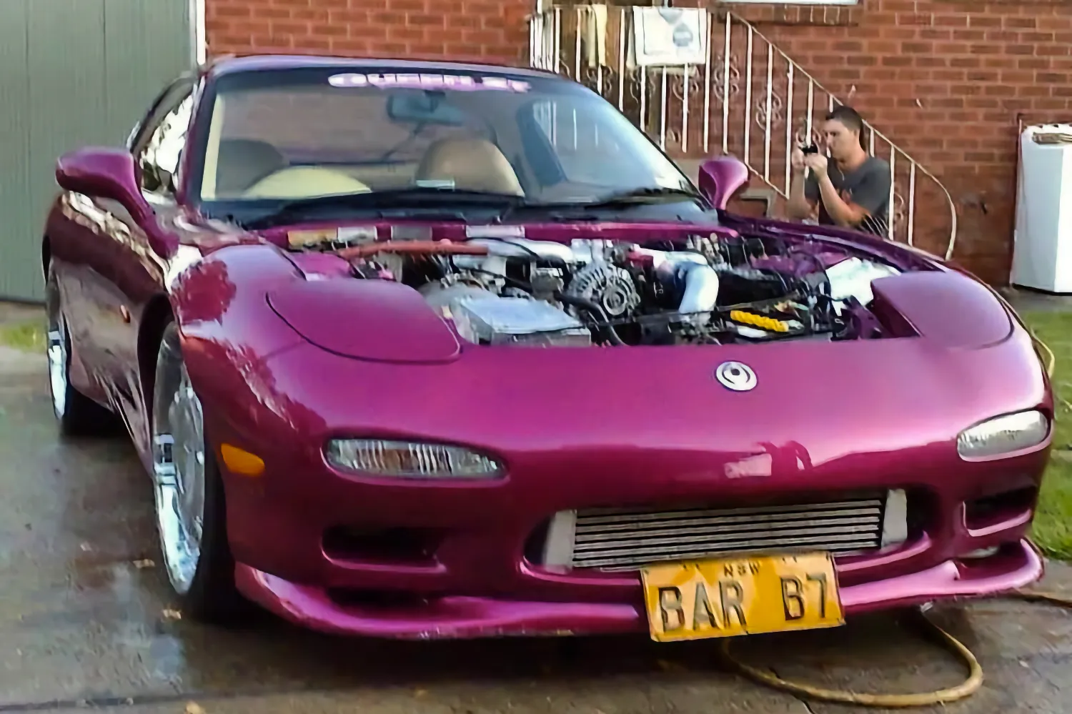 Purple FD RX7 parked in front of a house.
