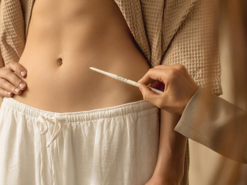 doctor drawing on a patient's stomach