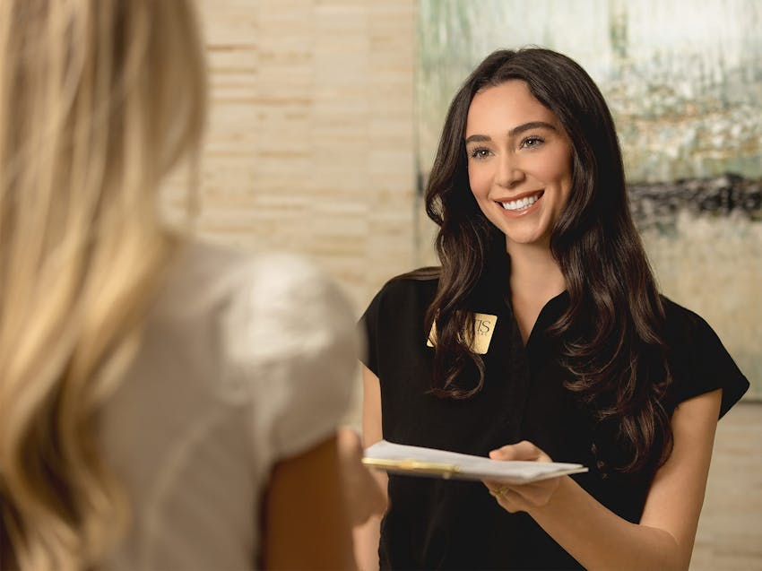 receptionist giving paperwork to a patient