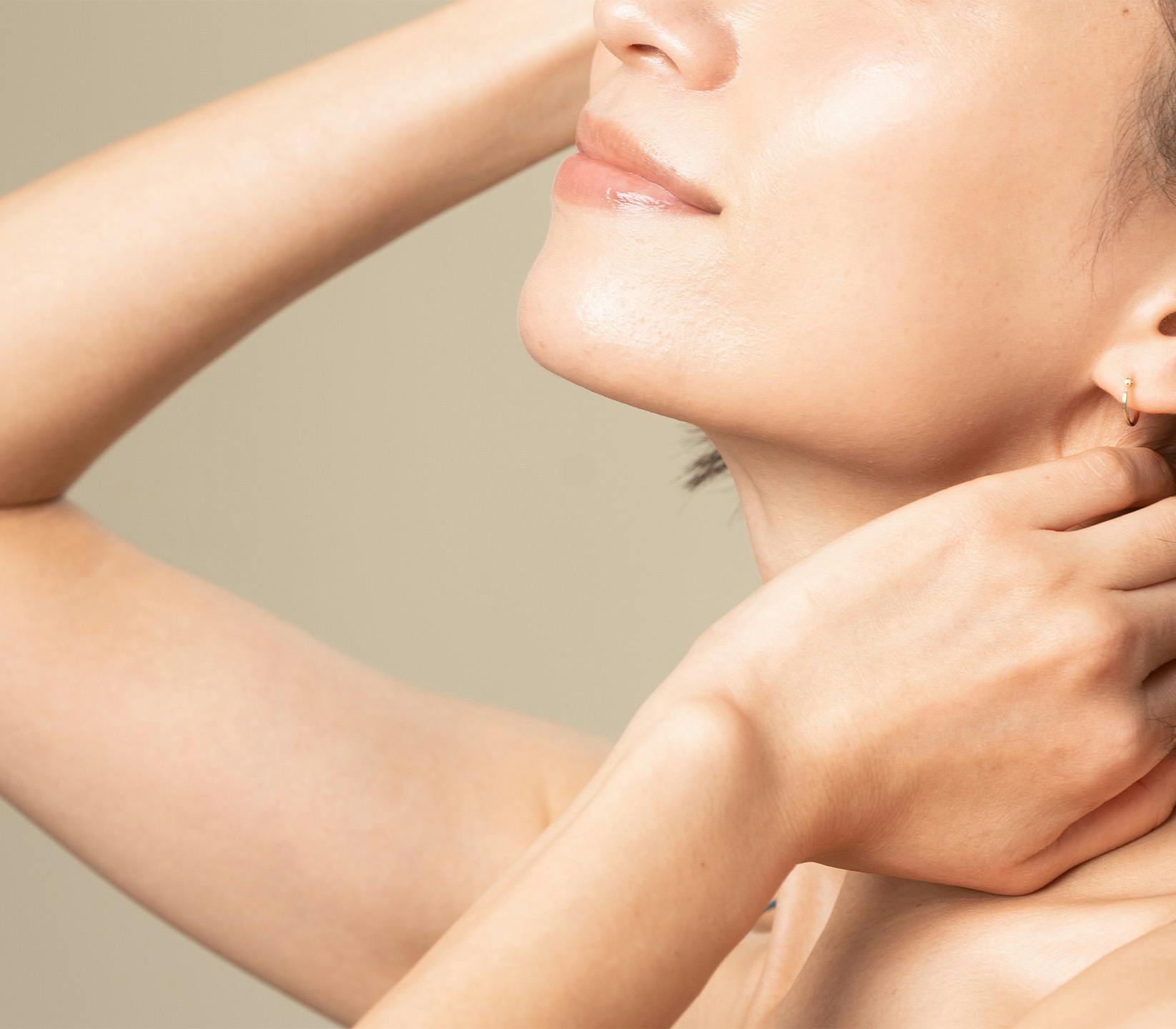 Woman with arm up and hand on neck