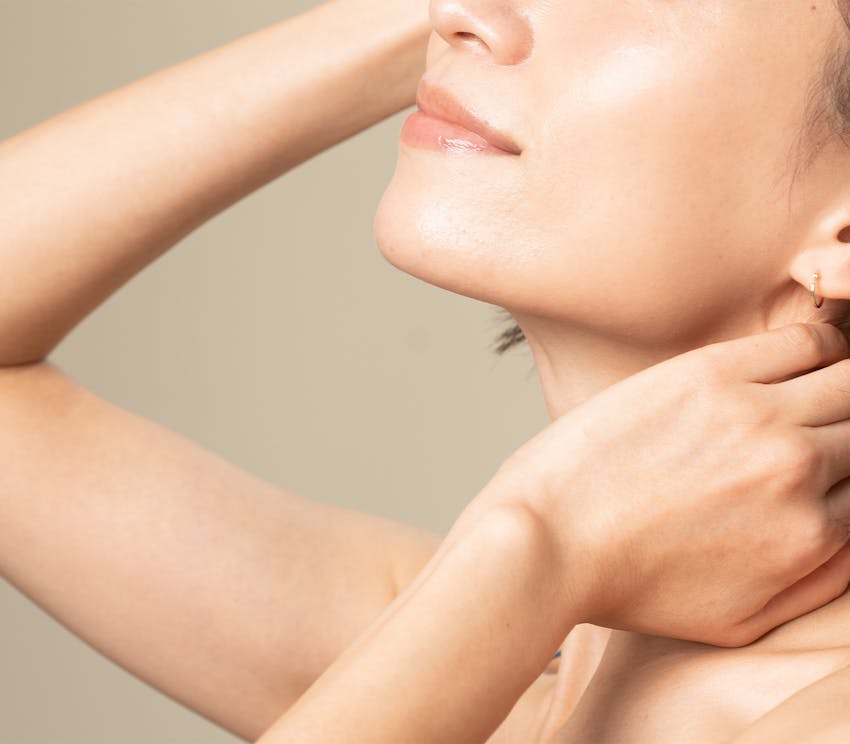 Woman with arm up and hand on neck