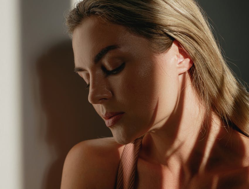 woman looking down with a shadow casted on face
