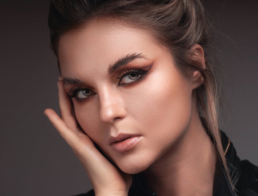 woman with hand on face looking to the side