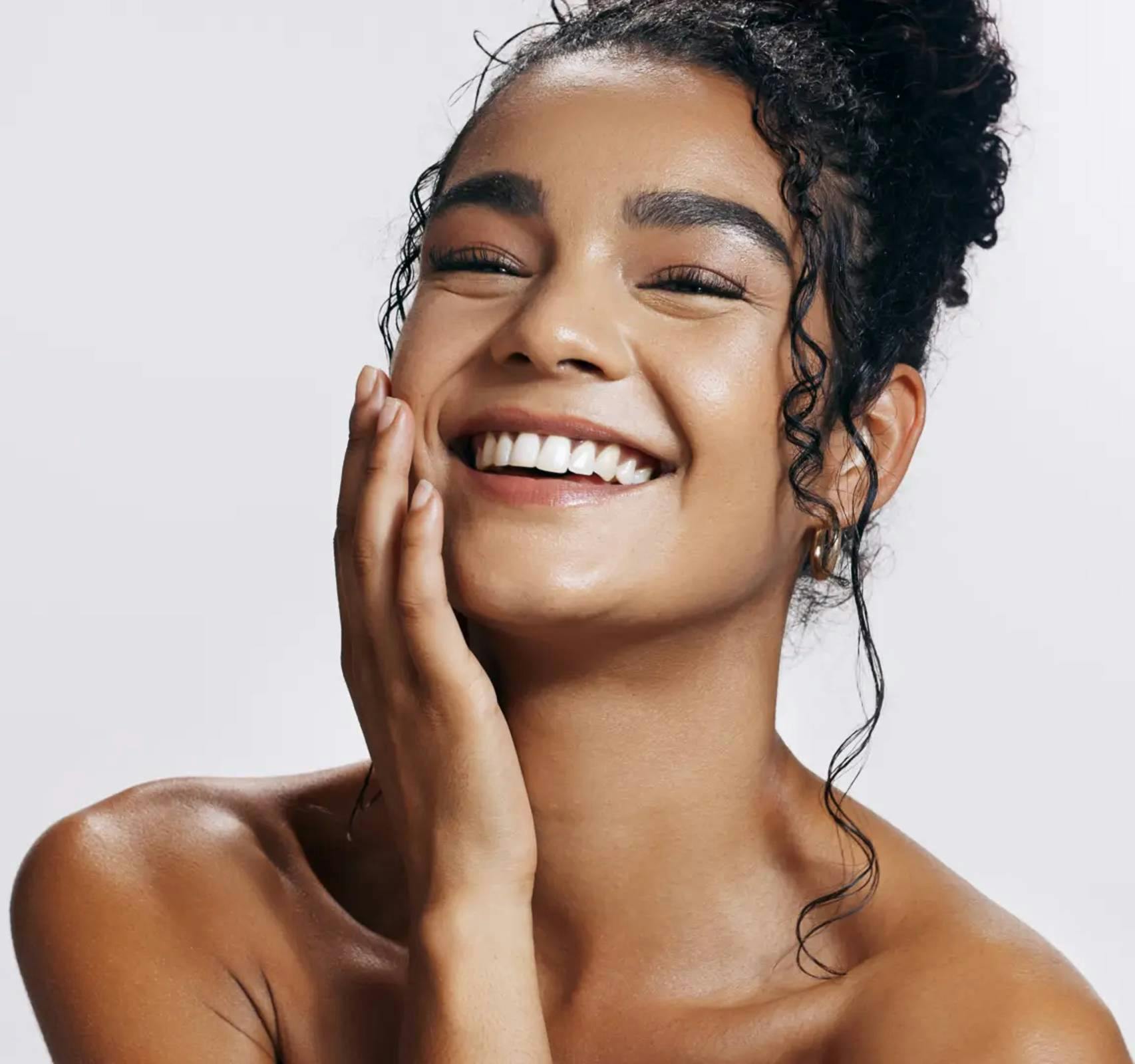 woman smiling with hand on face