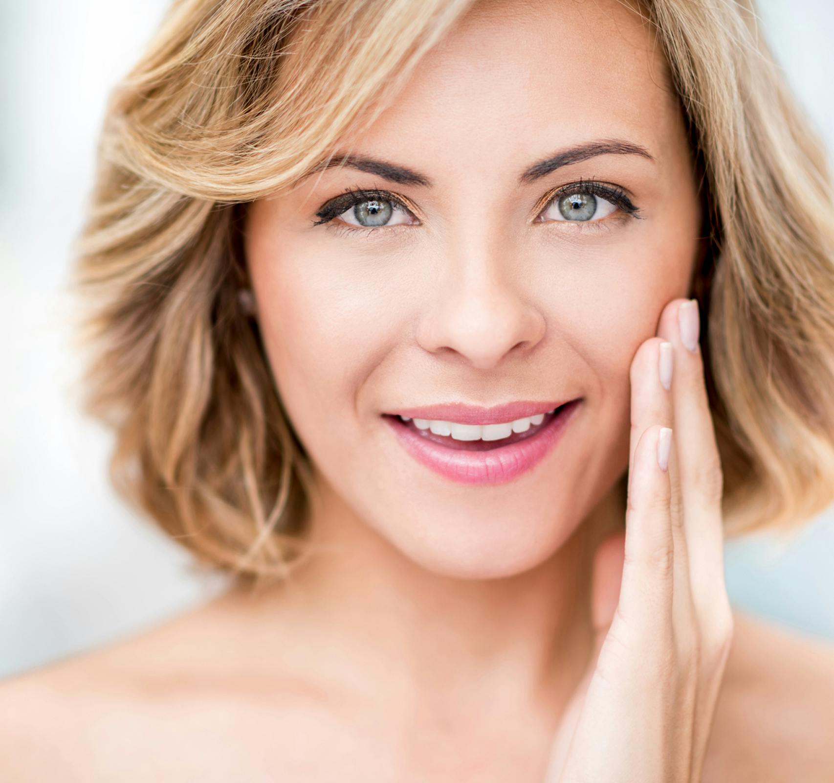 woman touching face smiling