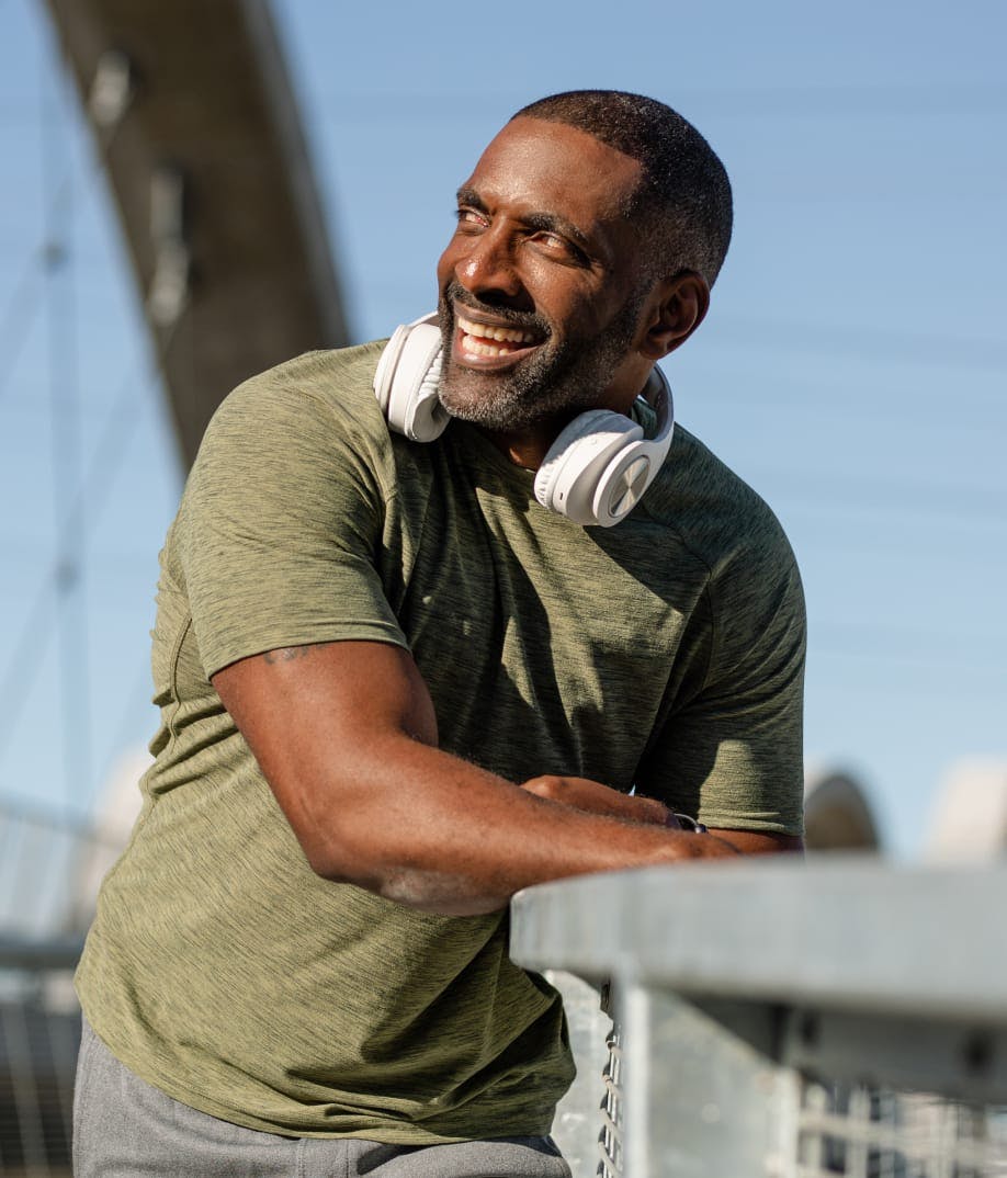 man smiling outside wearing headphones