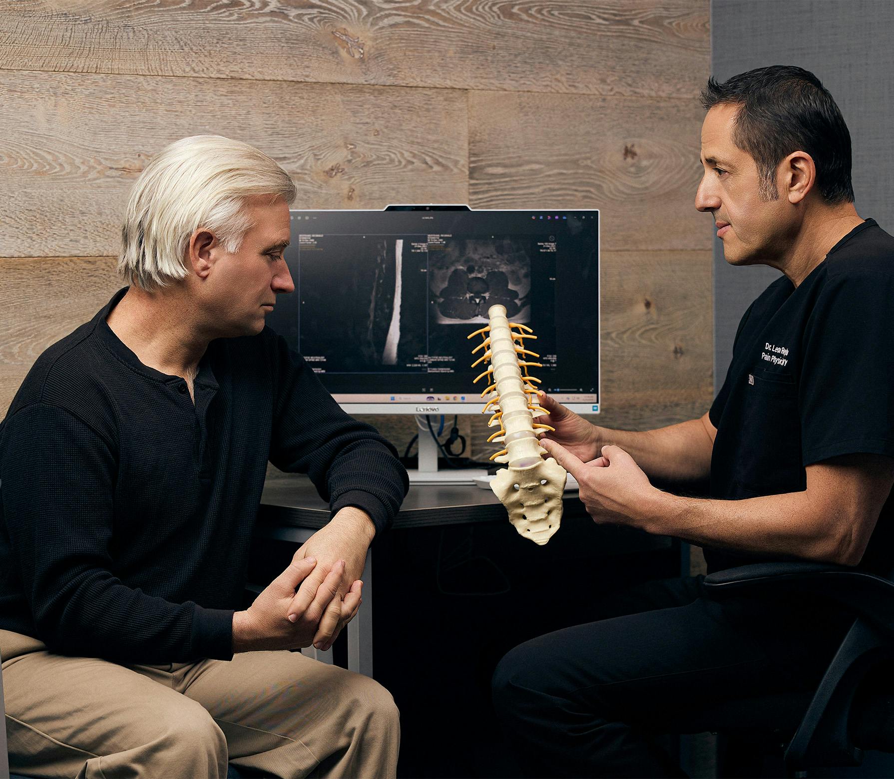 doctor and patient looking at a spine model