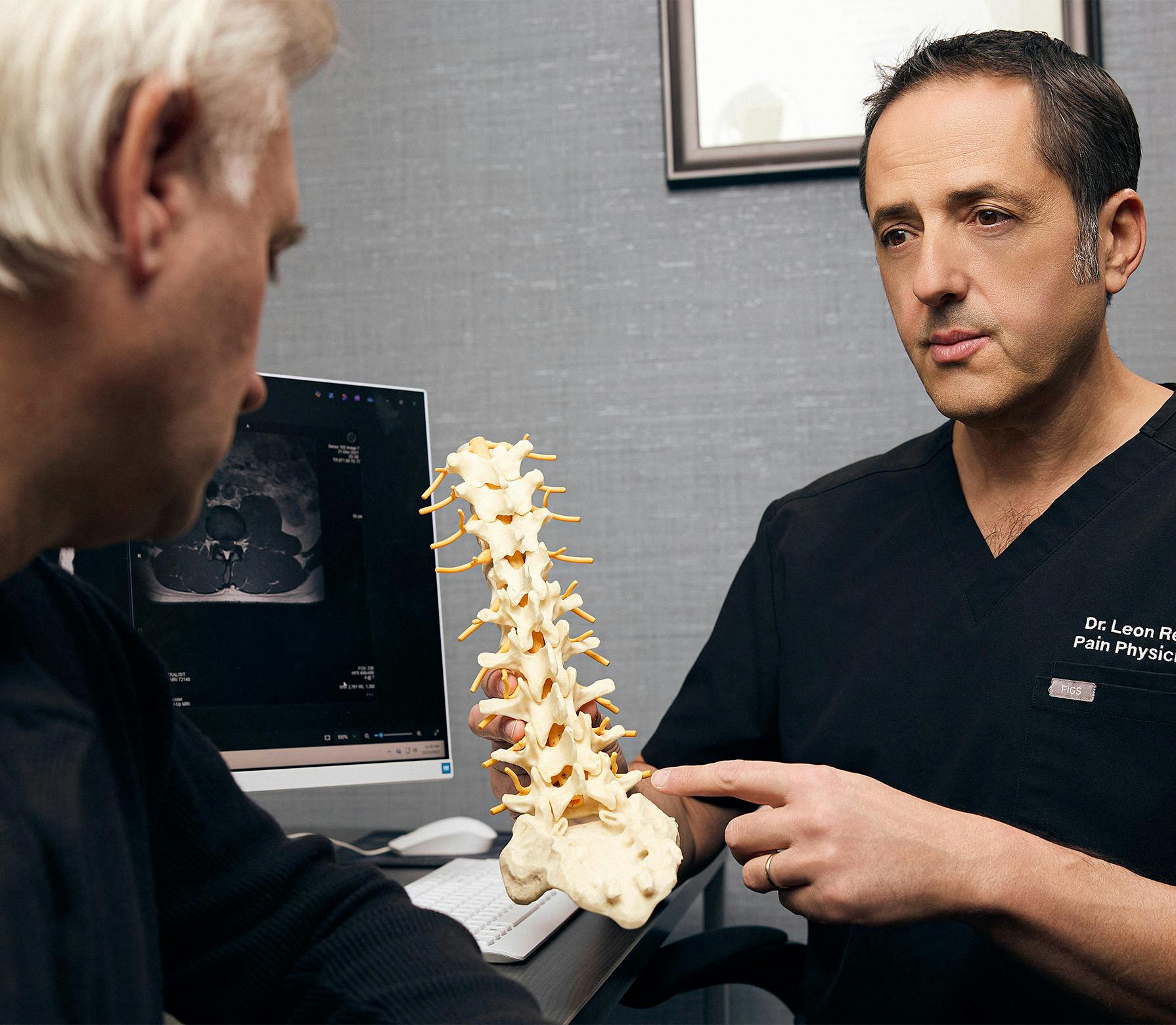 doctor showing a patient a spine model