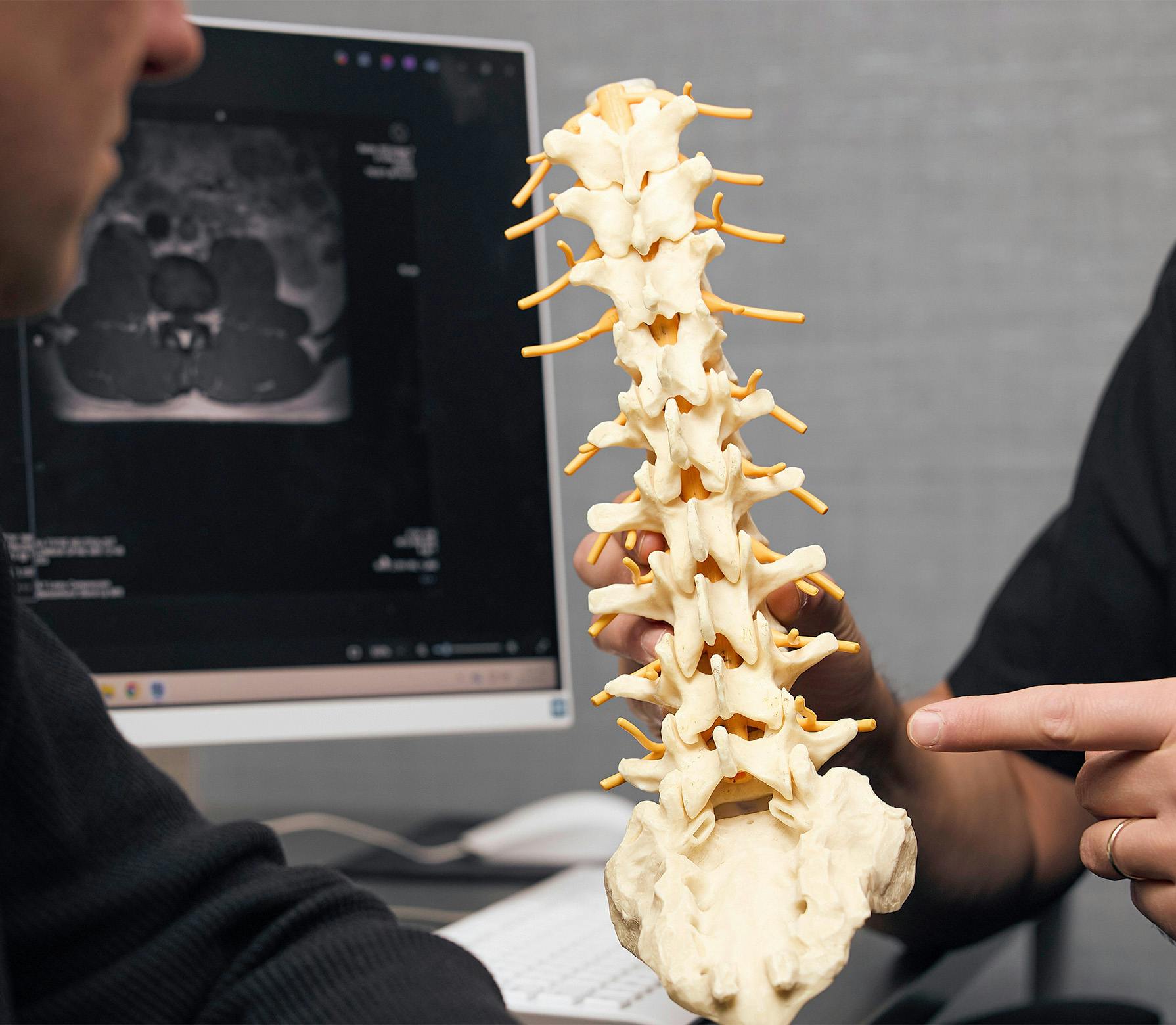 doctor and patient looking at a spine model