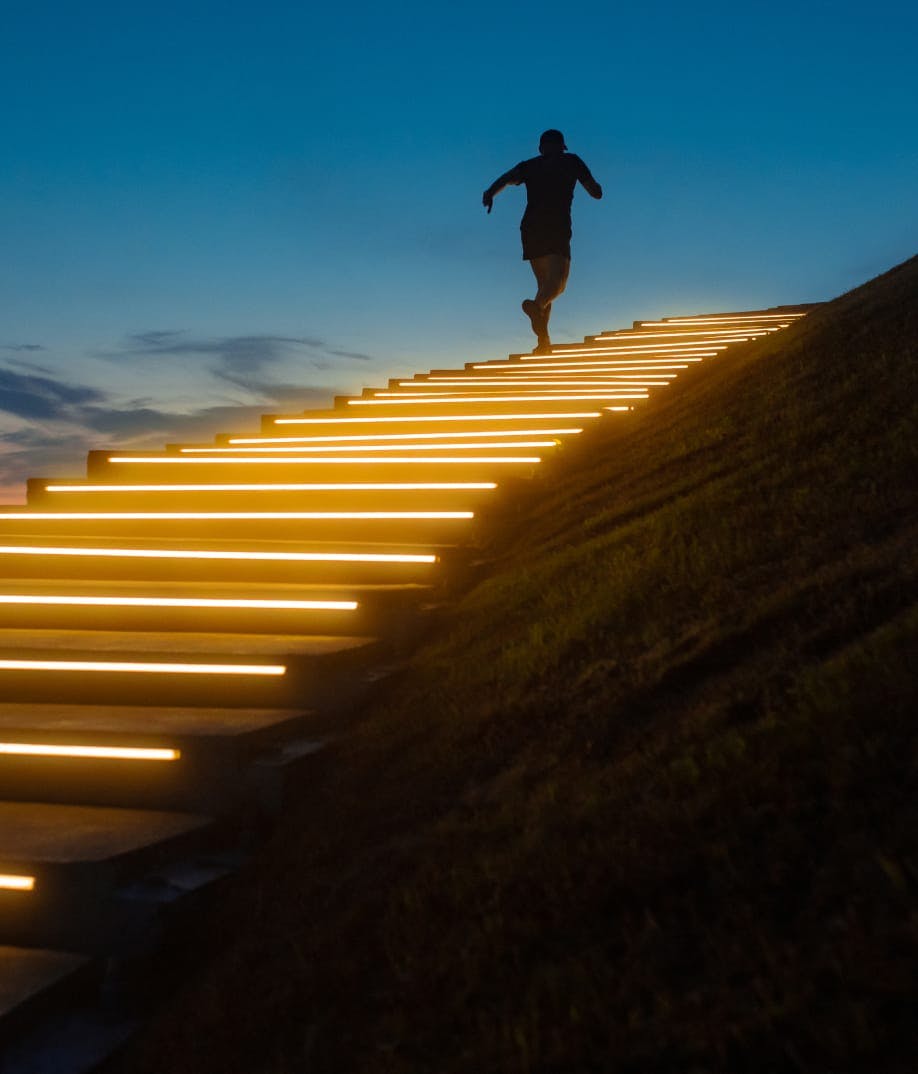 person running up stairs that have lights on them