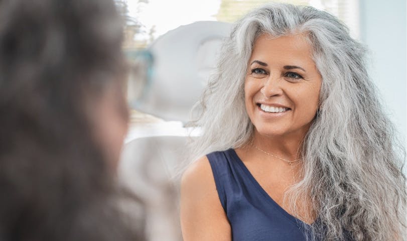 smiling patient in chair discussing with Dr Cernaianu