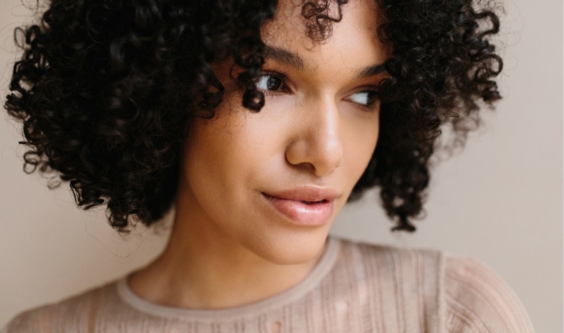 woman with short curly hair looking to her left