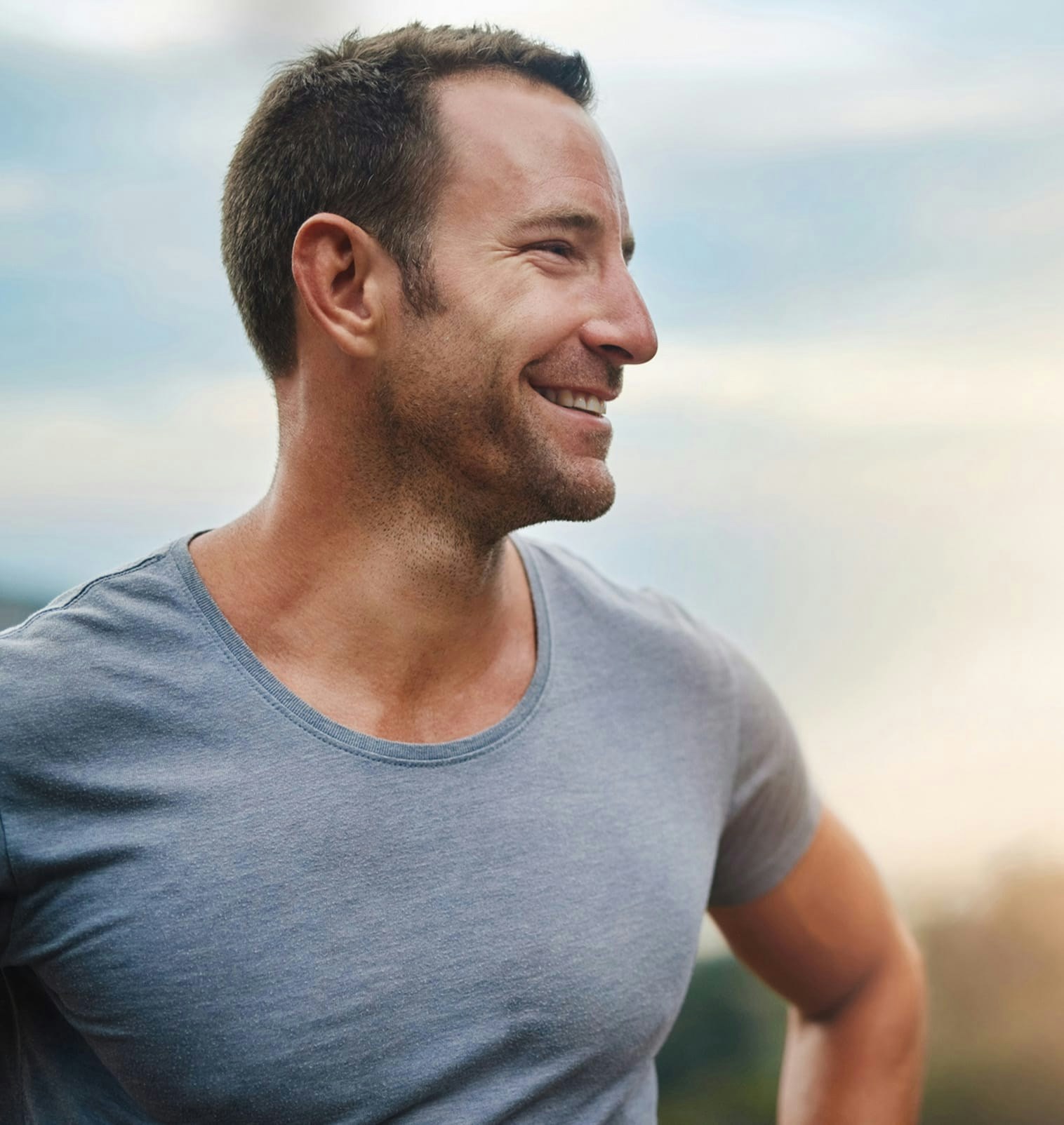 Man wearing a grey t-shirt smiling
