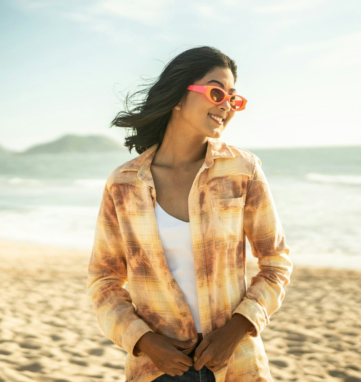 Woman with dark hair standing on the beach