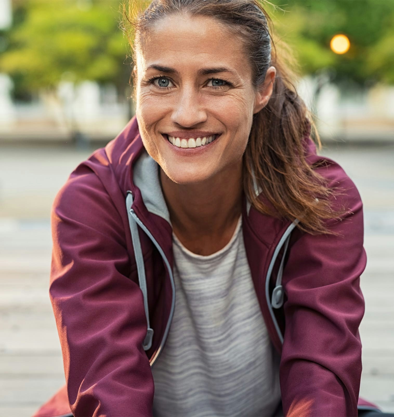 smiling woman in maroon athetic hoodie