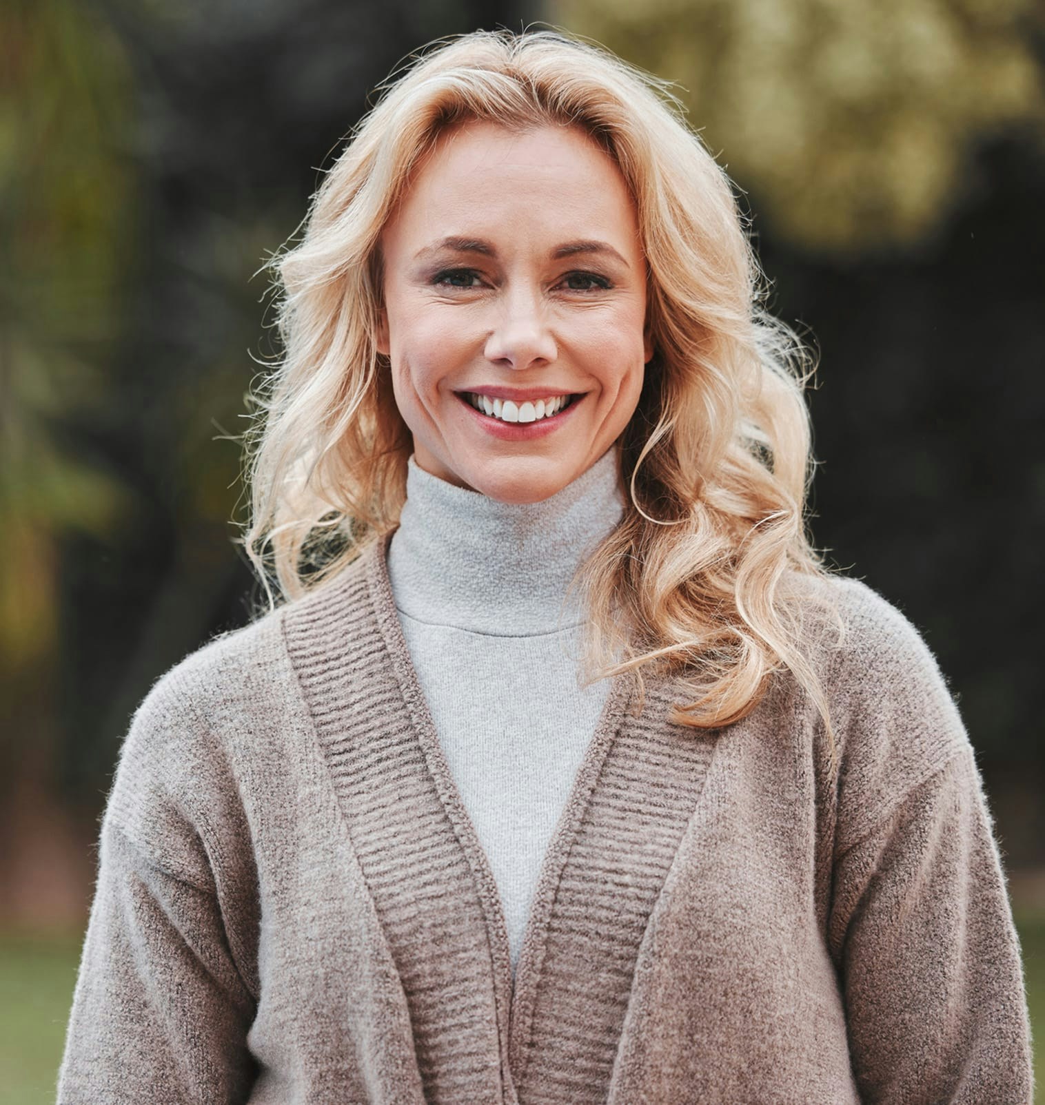 smiling woman wearing grey turtleneck