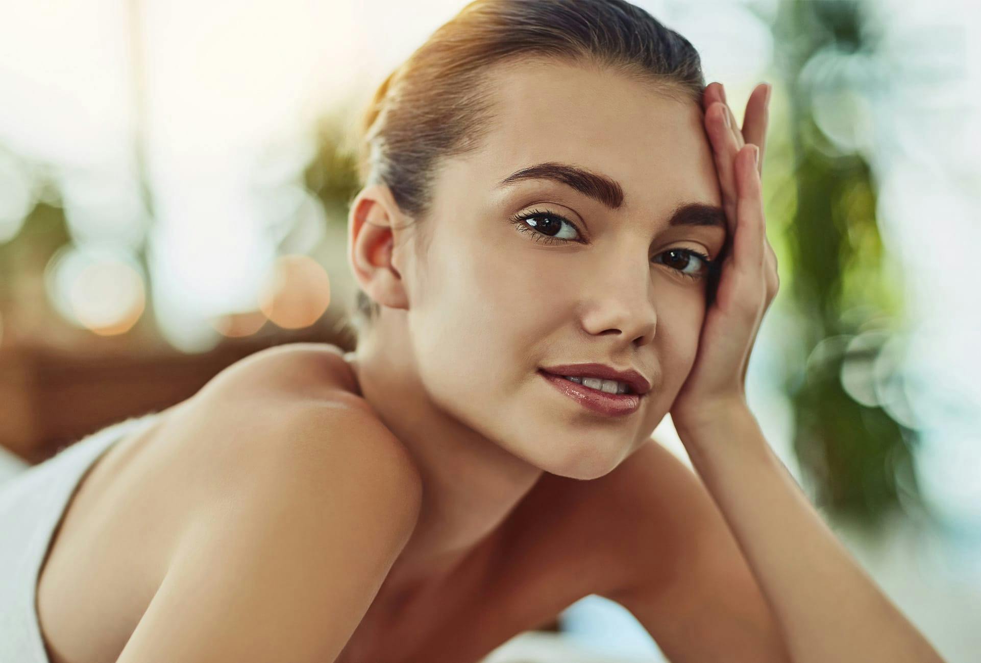 woman in towel holding up head with left hand