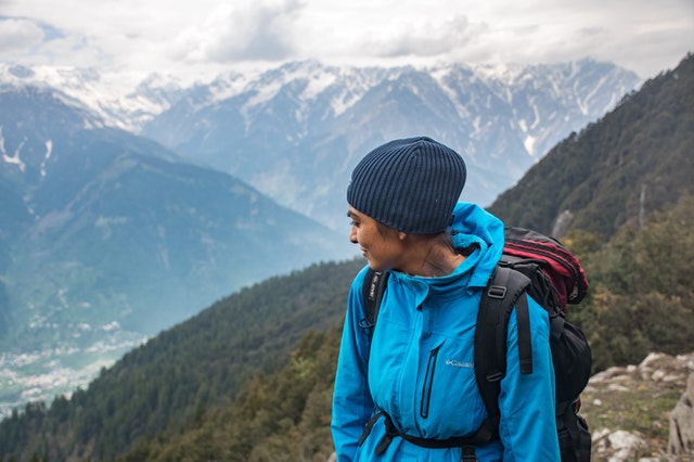 woman hiking and looking down a mountain