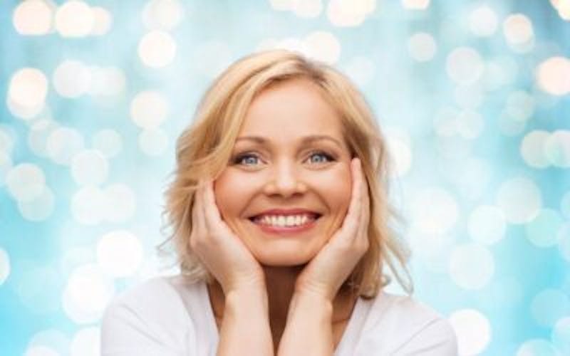 a woman with blonde hair and blue eyes posing for a picture