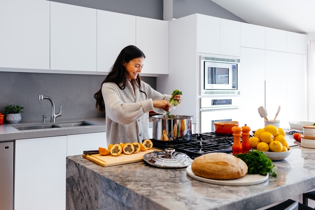 woman smiling and cooking