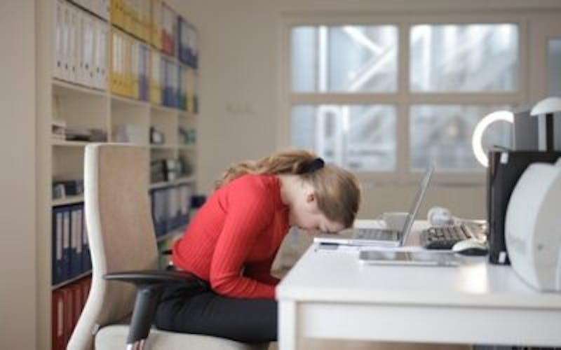 there is a woman sitting at a desk with a laptop