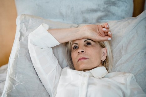woman laying down with arm covering forehead