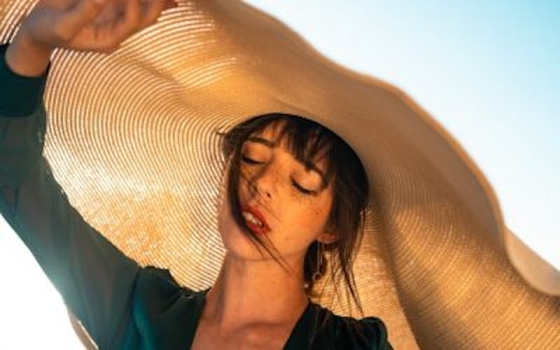 woman wearing a large hat on a beach