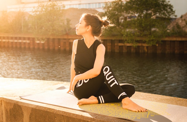 woman doing yoga near water