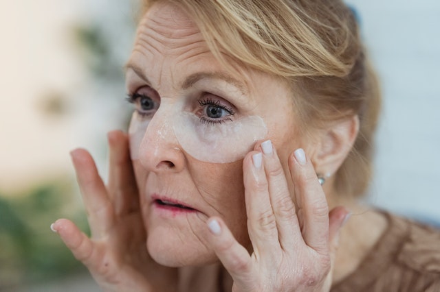 woman applying skincare products on face