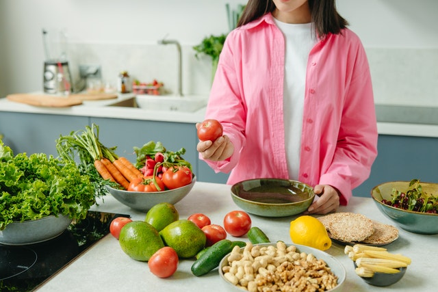 woman surrounded by healthy food on counter