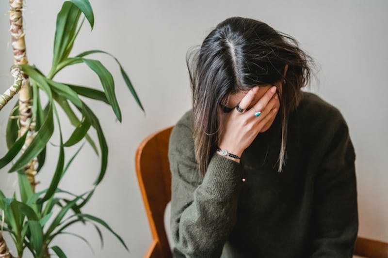 woman sitting in a chair with her hands on her face