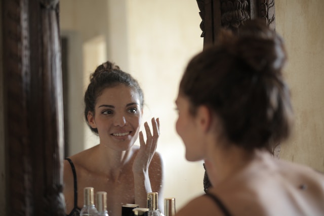 woman looking in mirror
