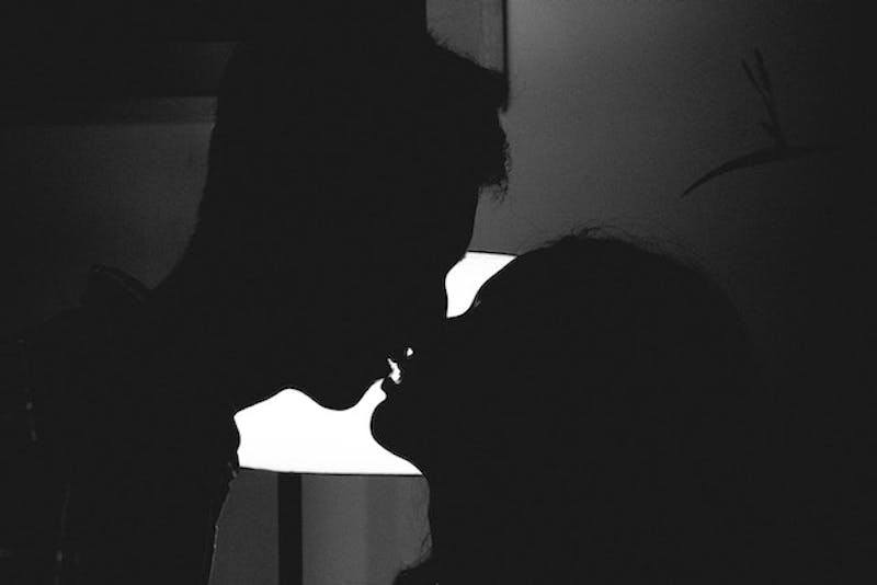 man and a woman kissing in the dark