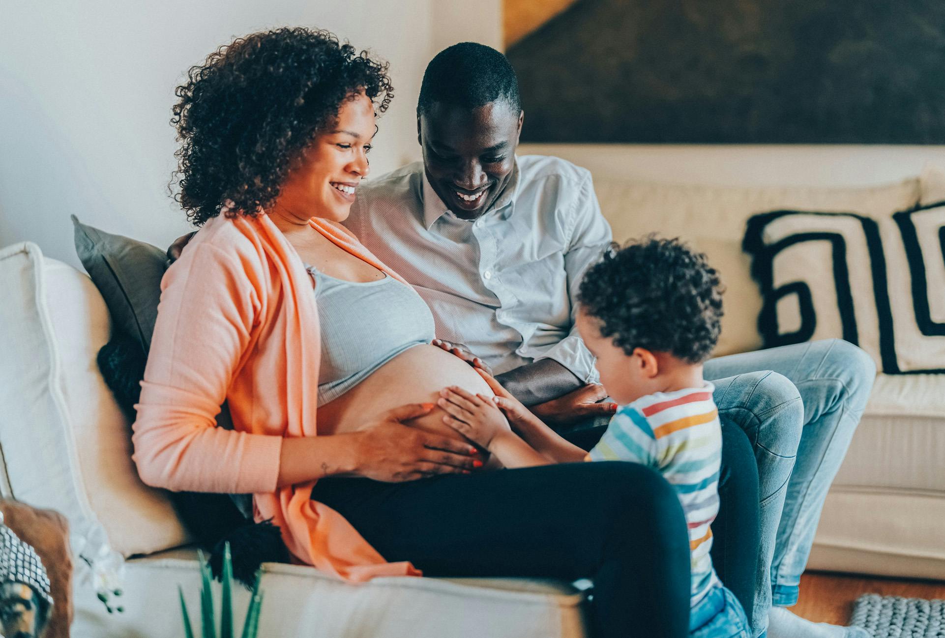 Pregnant woman and husband letting son feel her stomach