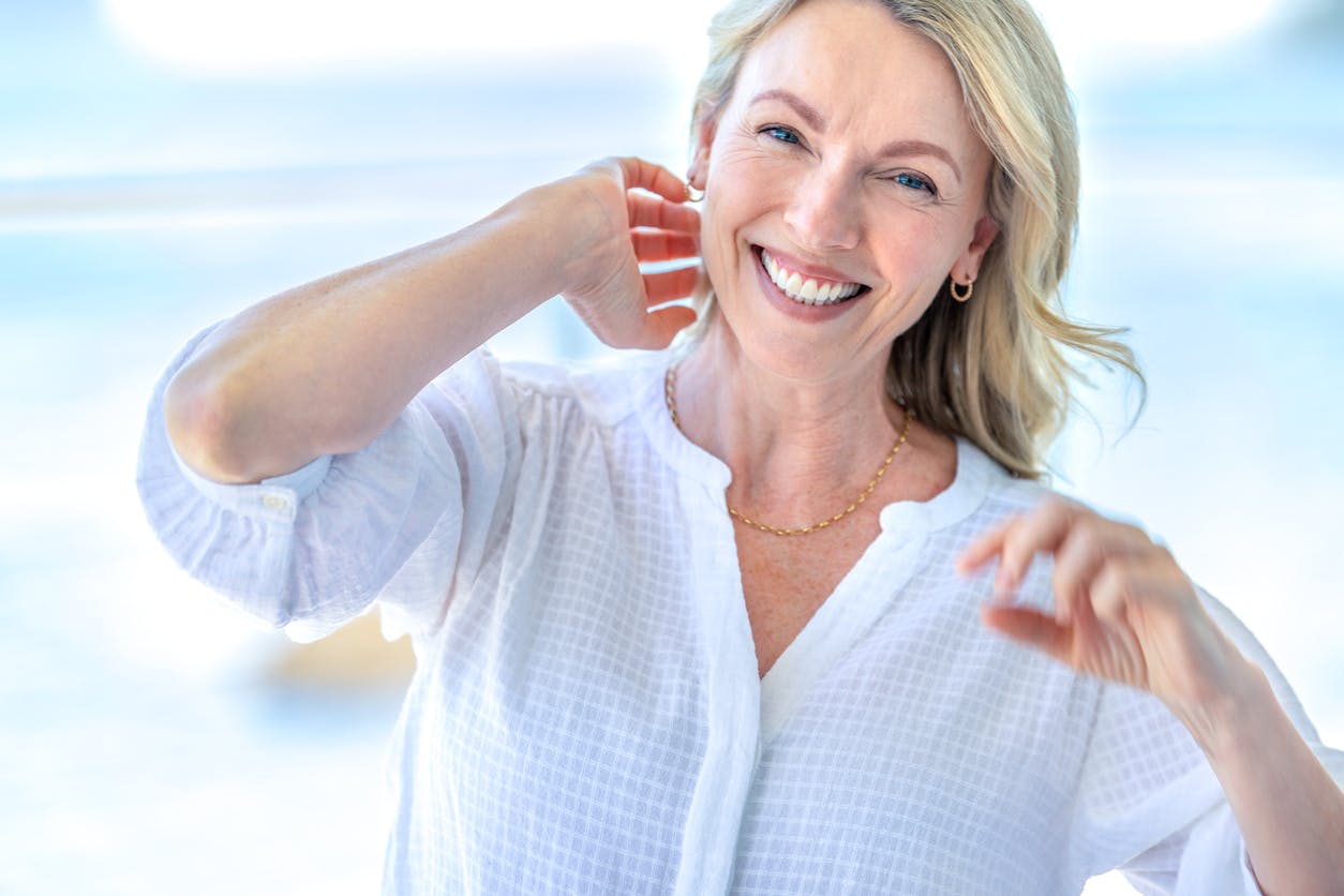 woman smiling and brushing hair back