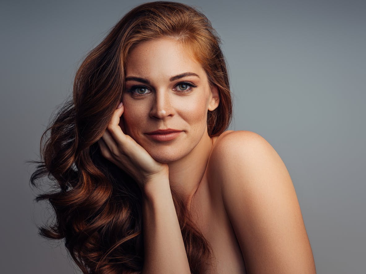 Woman with perfect skin smiles at camera in studio shoot emulating the potential results of Potenza microneedling in Thousand Oaks.