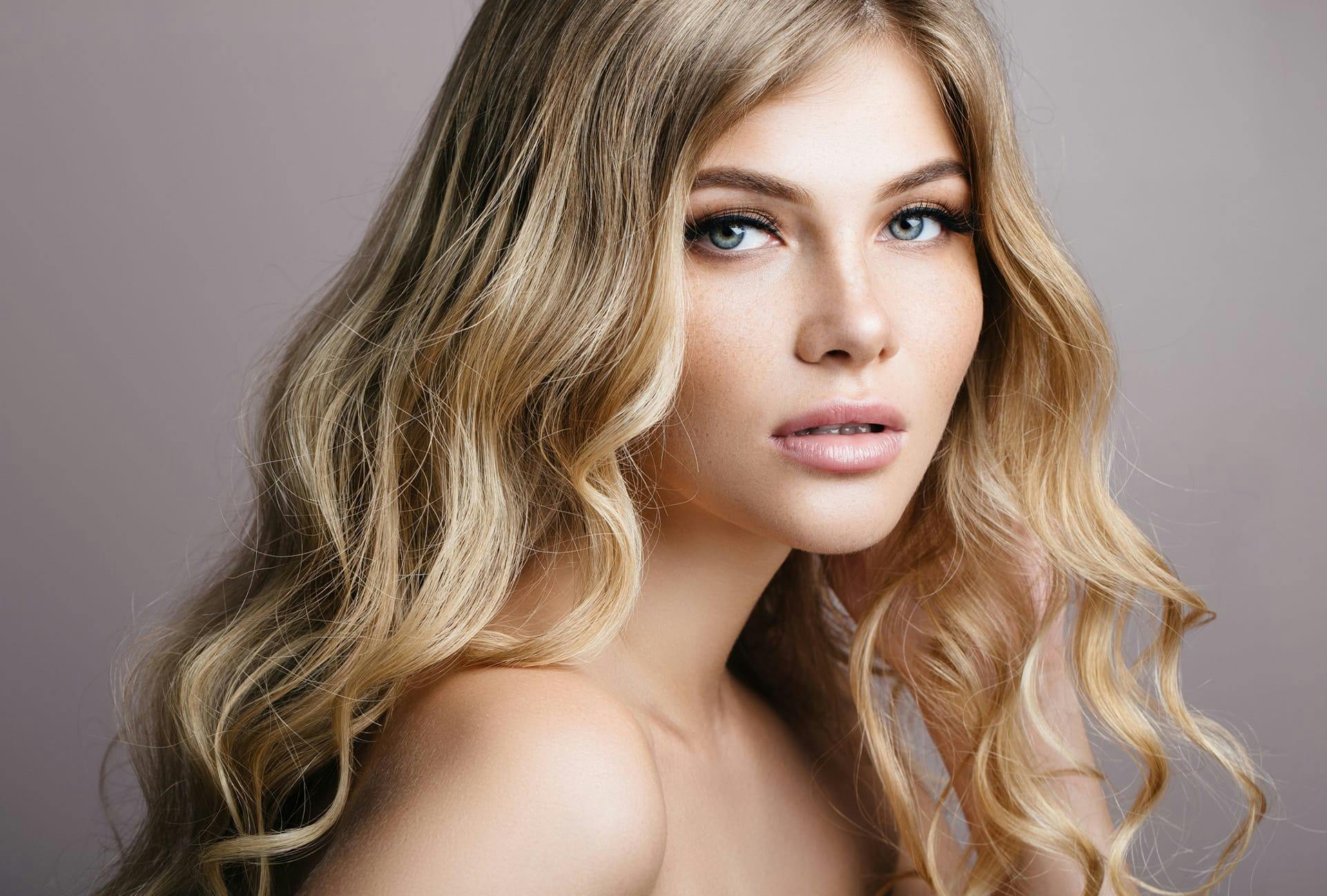 Woman with smooth skin and wavy blonde hair
